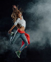 Performer dancing on dark background © stokkete