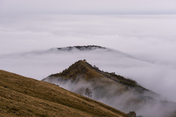 Scenics mountain peaks surrounded by fog landscape in autumn day outdoor