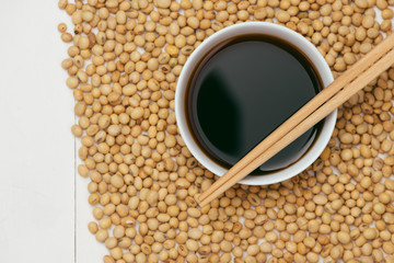 Soy sauce and soy bean with chopsticks on wooden table