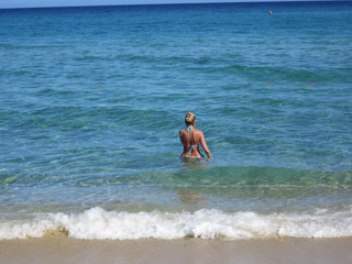 donna in costume mentre fa il bagno nel mare
