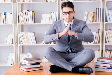 Businessman student in lotus position concentrating  in the libr