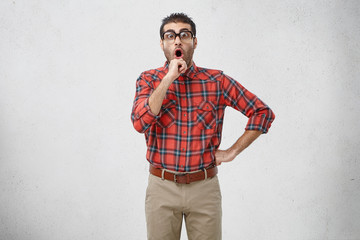 Picture of emotional adult Caucasian brunette guy with stubble wearing old fashioned spectacles and...