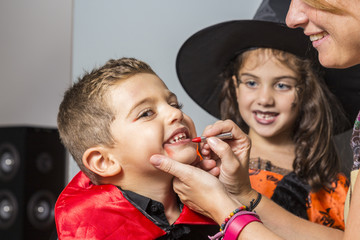 Mother painting faces at Halloween © Victor
