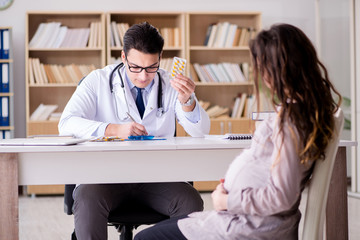 Fototapeta premium Pregnant woman visiting doctor for consultation