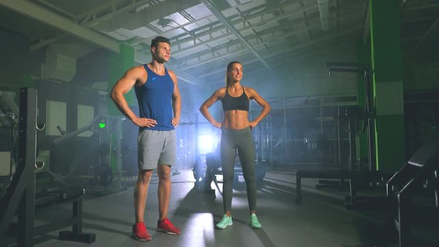 The sportsman and sportswoman stand in the fitness center