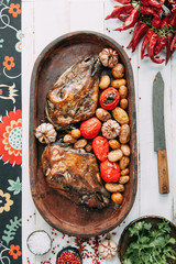the bull's head baked with vegetables and potatoes and garlic on a wooden Board