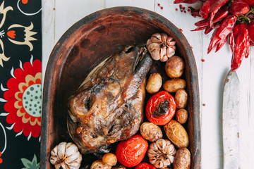 the bull's head baked with vegetables and potatoes and garlic on a wooden Board