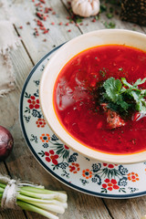 borscht with dill and parsley,with bread and spices on wooden background