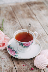 tea set in composition with flowers and marshmallows. Coffee mug on a saucer, a teapot and a sugar bowl. Filmed in the interior