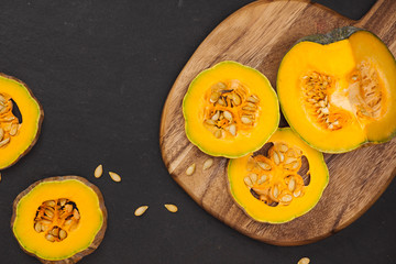 Delicious fresh pieces of ripe pumpkin on wooden background