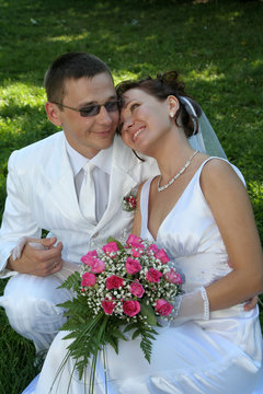 the groom holds the bride's hand against the blue sky