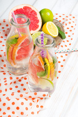 Infused flavored water with fresh fruits on white wooden background.Refreshing summer homemade  detox water