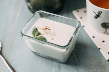 yogurt with mint on wooden white table