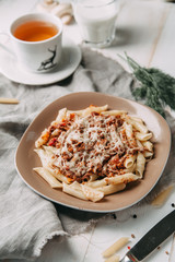 pasta with beef in composition on wooden table
