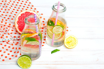 Infused flavored water with fresh fruits on white wooden background.Refreshing summer homemade  detox water