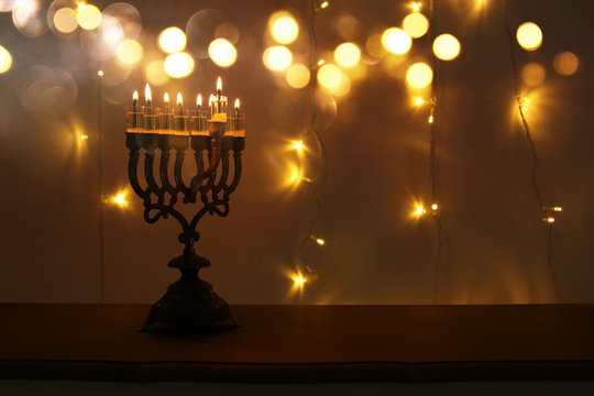 Low key image of jewish holiday Hanukkah background with menorah (traditional candelabra) and burning candles