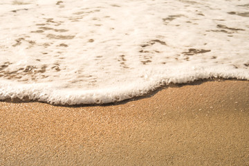 Background soft wave of Sea with foam on sandy beach.