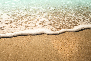 Background soft wave of Sea with foam on sandy beach.
