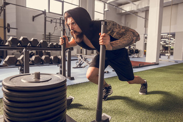 Fitness sled push man pushing weights workout exercise