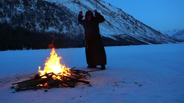 a mad monk dances around the campfire
