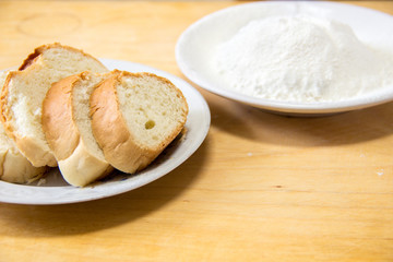 Slices of bread and wheat flour in a white plate on the table