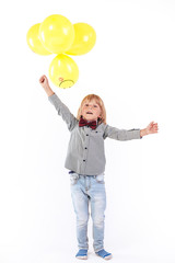 Stylish little boy dressed in red bow tie holding air balloon isolated on white background. Smile.
