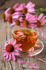 Cup of echinacea tea on old wooden table - obrazy, fototapety, plakaty
