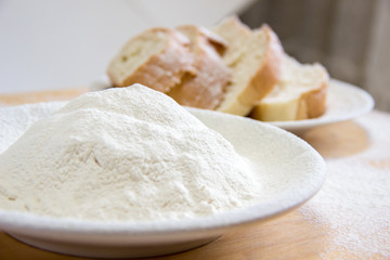 Slices of bread and wheat flour in a white plate on the table