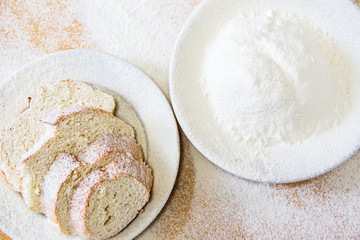 Slices of bread and wheat flour in a white plate on the table