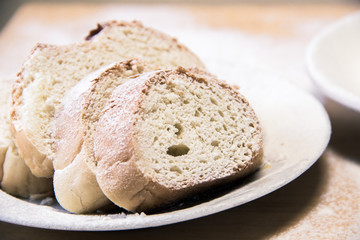 Poudered slices of bread in a white plate on the table
