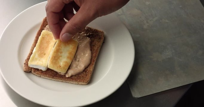 Cooking a rustic brie and ham sandwich with mustard sauce in an industrial style kitchen