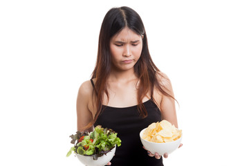 Young Asian woman with potato chips and salad.