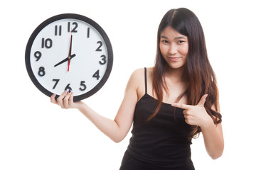 Young Asian woman point to a clock.