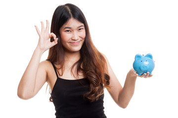 Asian woman show OK  with pig coin bank.