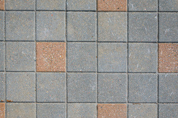 Naklejka premium Gray Concrete Square Paving Stone Texture with Inserts from a Red Stone Blocks. Landscaping Background Concept