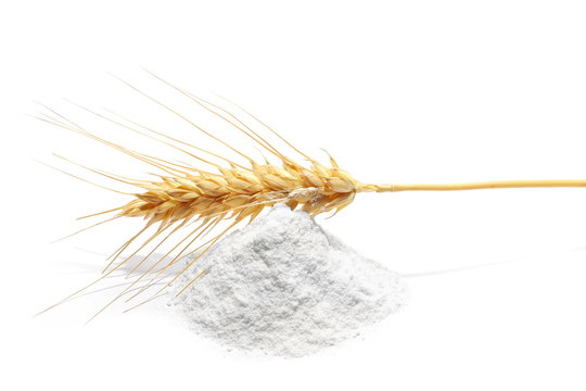 pile flour and wheat ears isolated on white background