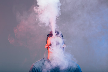 Vaper smoke electronic cigarette outdoor near wall