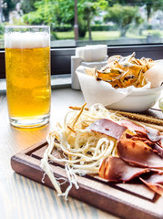 Goblet of beer with salty snacks on the table at the bar.
