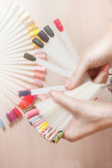 Top view woman choose manicure colorful nail polish. Nail technician shows the color palette of nail services in beauty salon store. spa treatments. beauty and fashion concept.
