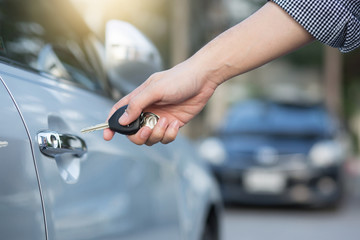 Cropped view of  Closeup of a man's hand inserting key into the door lock of a car