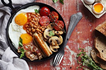 Traditional english breakfast. Pan with full english breakfast overhead rustic wooden table....