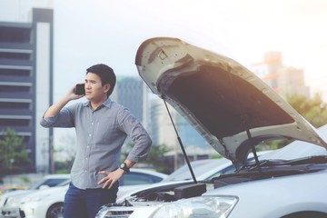 Angry man stand in front a broken car calling for assistance phone.