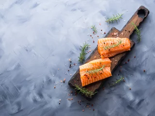 Fotobehang Raw salmon pieces on wooden board with herbs, salt and spices © tenkende