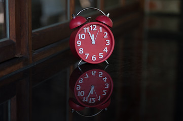 Retro alarm clock with five minutes to twelve o'clock.