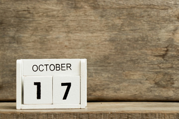 White block calendar present date 17 and month October on wood background