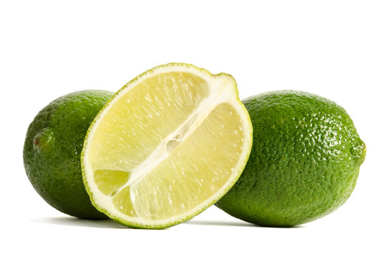 two limes with half of a juicy lime isolated on white background