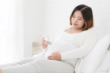 Obraz na płótnie Canvas Asian pregnant women drink water