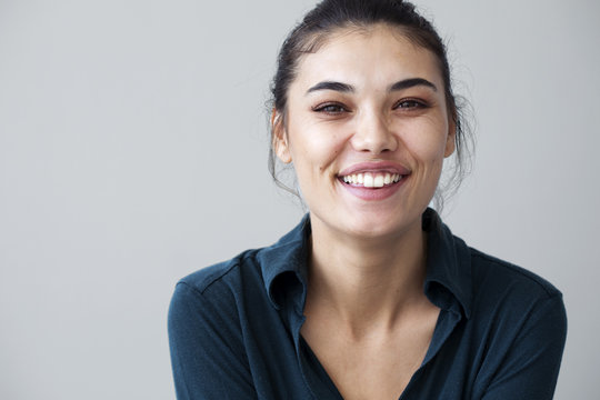 Young woman happy on gray background