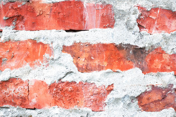 Texture of an old brick wall. Grunge red background of stone and cement. The shabby facade of the building with old bricks and damaged plaster. Abstract banner with copy space.