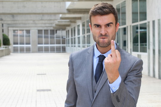 Moody businessman showing a middle finger 